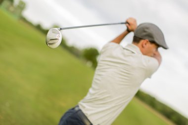 Golf oynayan genç adam.