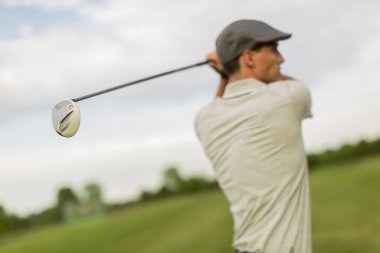 Golf oynayan genç adam.