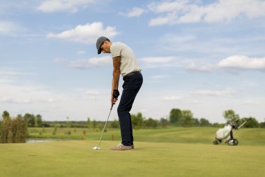 Golf oynayan genç adam.