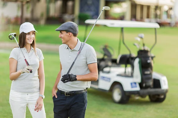 Jeune couple en voiturette de golf — Photo