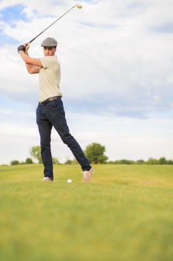 Golf oynayan genç adam.