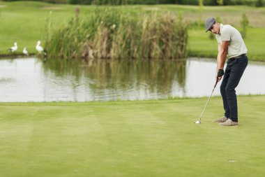 Golf oynayan genç adam.