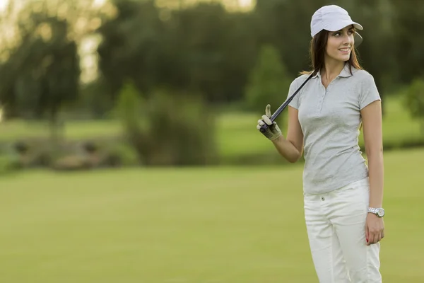 Jeune femme jouant au golf — Photo