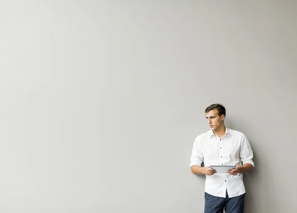 Man with tablet by the wall — Stock Photo, Image
