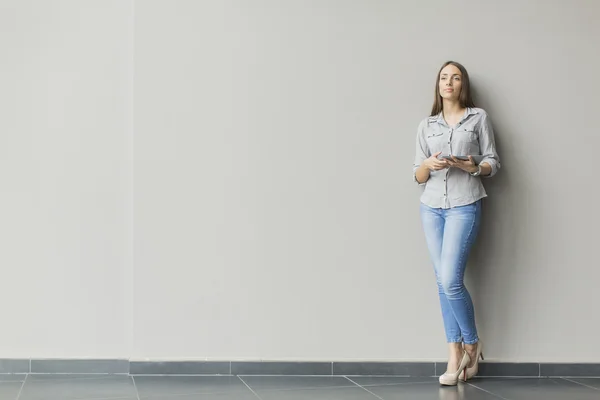 Frau mit Tablet an der Wand — Stockfoto