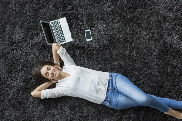 Mujer joven relajándose en la alfombra —  Fotos de Stock