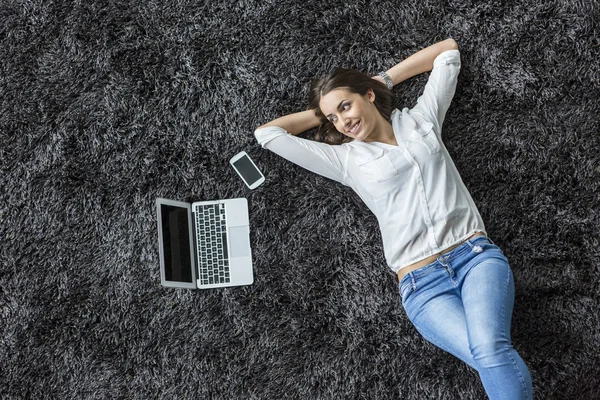 Молодая женщина лежит на ковре — стоковое фото