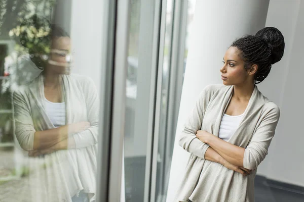 Woman standing near window — Stock Photo, Image