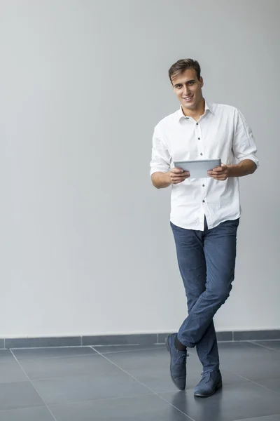 Man met tablet door de muur — Stockfoto