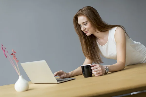 Jovem com laptop no escritório — Fotografia de Stock