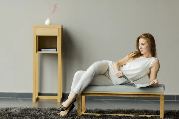 Jeune femme lisant un livre dans la chambre — Photo