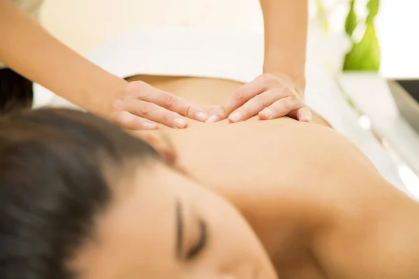 Jovem mulher fazendo uma massagem — Fotografia de Stock