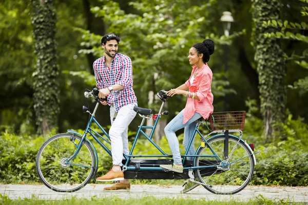 Young couple riding on the tandem bicycle — Stock Photo, Image