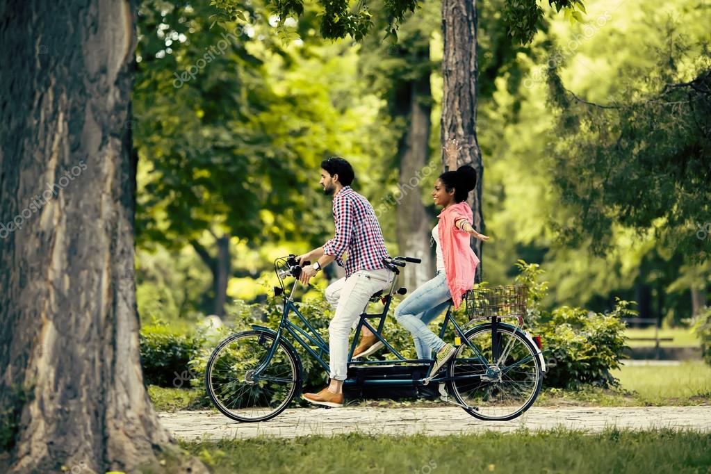 Young Couple Riding On The Tandem Bicycle Stock Photo By