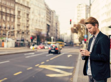 Sokaktaki cep telefonlu genç adam.