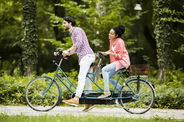 Jovem casal andando na bicicleta tandem — Fotografia de Stock