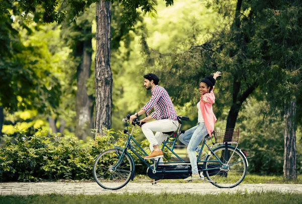 Young couple riding on the tandem bicycle — Stock Photo, Image