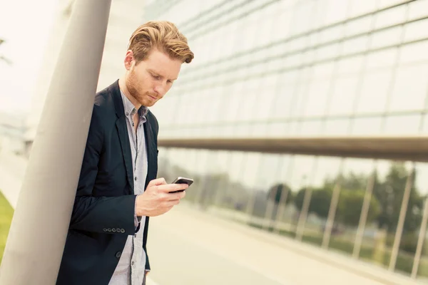 Junger Mann mit Handy auf der Straße — Stockfoto