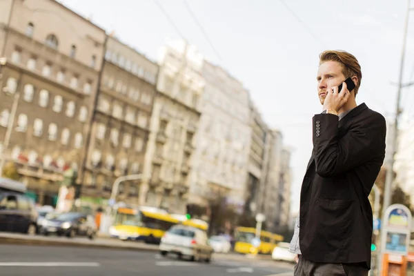 Jovem na rua com telefone celular — Fotografia de Stock