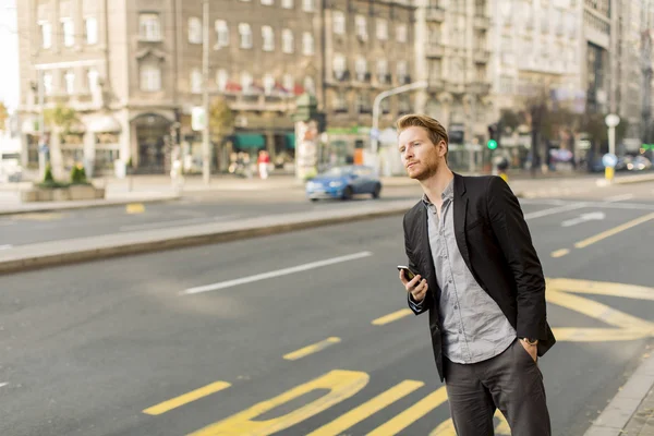 Young man on the street with mobile phone — Stock Photo, Image