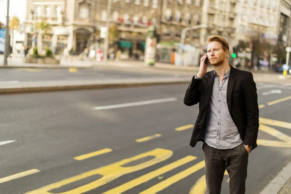 Young man on the street with mobile phone — Stock Photo, Image