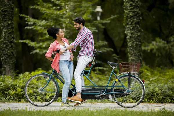 Young couple riding on the tandem bicycle — Stock Photo, Image