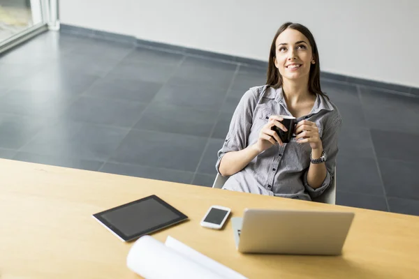 Jeune femme travaillant dans le bureau — Photo