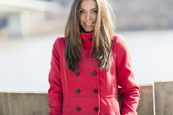 Pretty young woman in red coat — Stock Photo, Image