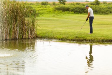 Golf oynayan genç adam.