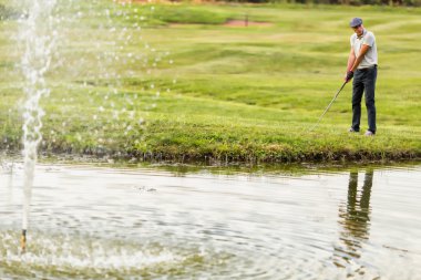 Golf oynayan genç adam.
