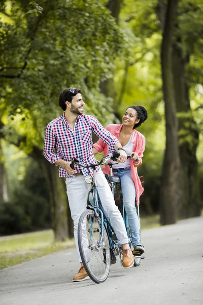 Pareja joven montando en la bicicleta tándem — Foto de Stock