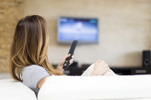 Jovem mulher assistindo TV — Fotografia de Stock