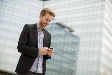 Sokaktaki cep telefonlu genç adam.