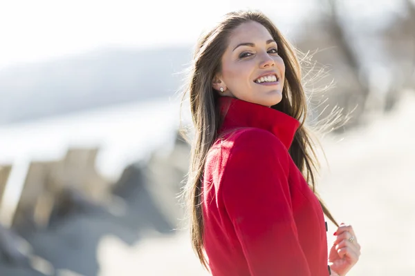 Pretty young woman in red coat — Stock Photo, Image