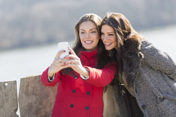 Mujeres jóvenes felices tomando fotos con teléfono móvil — Foto de Stock