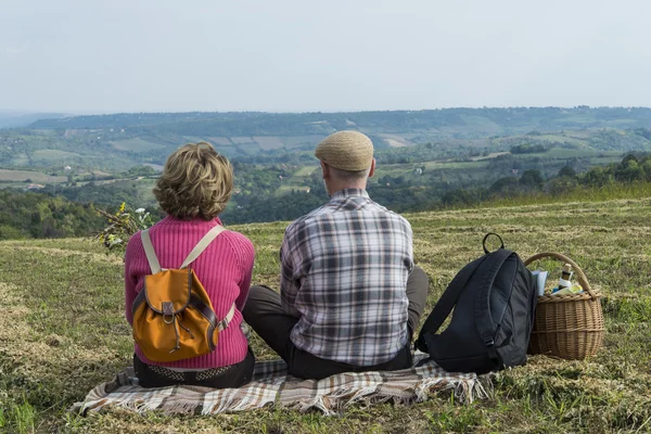 Pareja mayor sentada en el campo — Foto de Stock