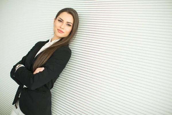 Joven mujer de negocios por la pared — Foto de Stock