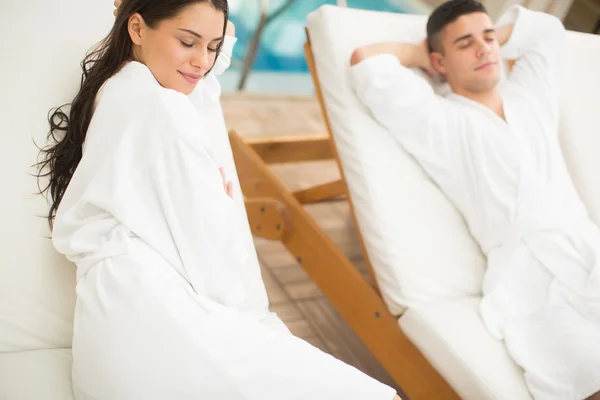 Jovem casal relaxante à beira da piscina — Fotografia de Stock