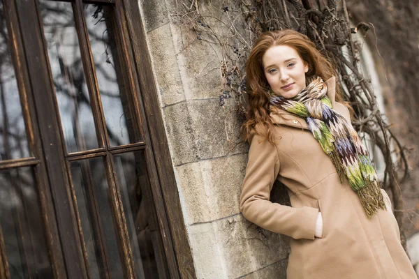 Young woman by the wall — Stock Photo, Image