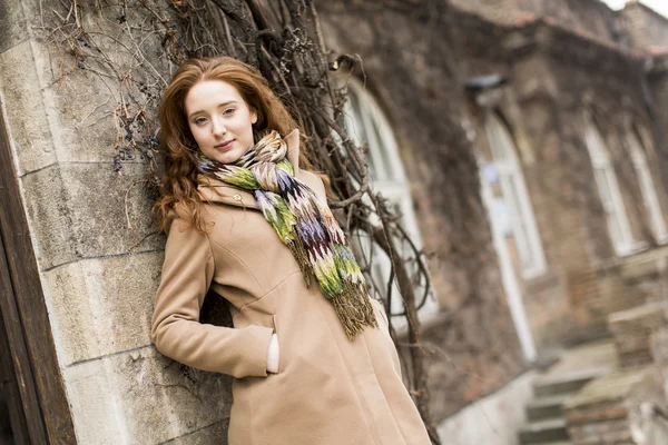 Young woman by the wall — Stock Photo, Image