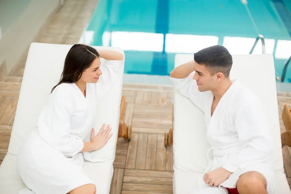 Giovane coppia rilassante a bordo piscina — Foto Stock