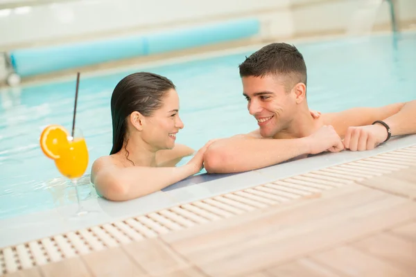 Молодая пара отдыхает в бассейне — стоковое фото