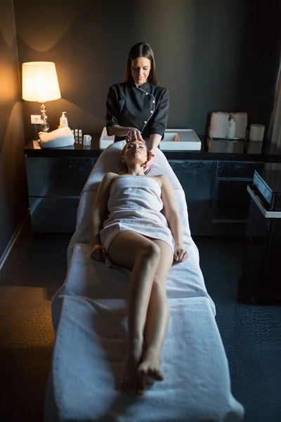 Jovem mulher fazendo uma massagem — Fotografia de Stock