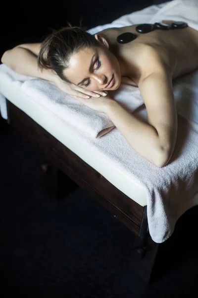 Junge Frau mit einer Massage mit heißen Steinen — Stockfoto
