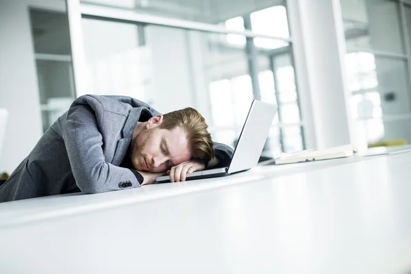 Unavený mladý muž v kanceláři — Stock fotografie