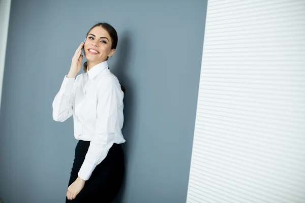 Jonge vrouw door de muur — Stockfoto