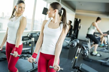 Genç adam spor salonunda antrenman yapıyor.