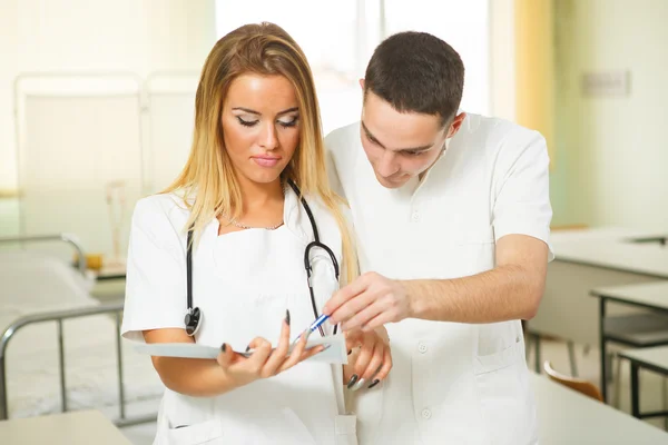 Young doctors looking at results in the office — Stock Photo, Image