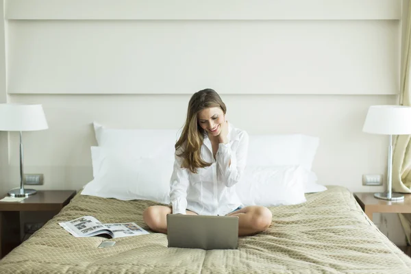 Dizüstü bilgisayar ile yatakta kadın — Stok fotoğraf