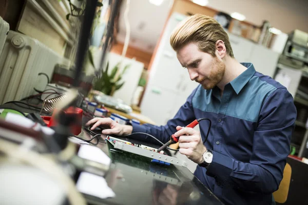 Jeune homme en atelier d'électronique — Photo